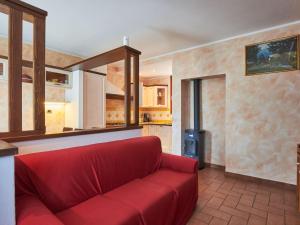 a red couch in a living room with a stove at Holiday Home Leonardo by Interhome in Sorico