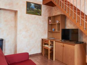 a living room with a desk with a tv and a staircase at Holiday Home Leonardo by Interhome in Sorico +31 photos