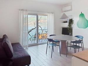 a living room with a table and chairs and a balcony at Apartment La Maison Blanche-1 by Interhome in Brenzone sul Garda