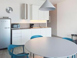 a kitchen with a white table and blue chairs at Apartment La Maison Blanche-1 by Interhome in Brenzone sul Garda +23 photos