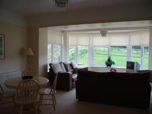 a living room with a couch and a table at Shallcross Hall Cottages - Blackbrook in Taxal