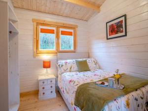 a small bedroom with a bed and a table at Dôl Werdd Lodge in Glanamman