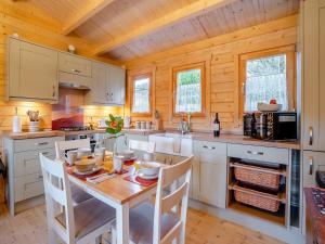 a kitchen with a table and chairs in a cabin at Dôl Werdd Lodge in Glanamman