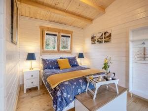 a bedroom with a bed and a table in a room at Dôl Werdd Lodge in Glanamman