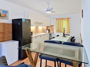 a kitchen with a glass table with chairs and a refrigerator at Holiday Home Gorana by Interhome in Mirce