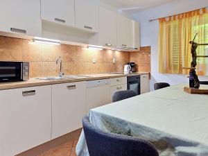 a kitchen with white cabinets and a table with chairs at Holiday Home Gorana by Interhome in Mirce +33 photos