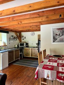 a kitchen with wooden ceilings and a table at Chez Jallot - Upper Gite in Vidaillat