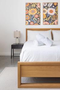 a bedroom with a white bed with two pictures on the wall at Stylish Pool Stay Near Brickell & Beach in Miami +9 photos