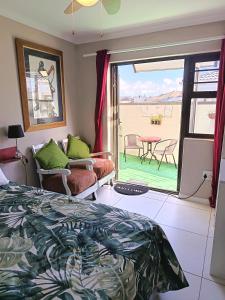 a bedroom with a bed and a view of a patio at Studio On Fairway in Langebaan