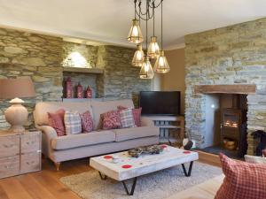 a living room with a couch and a fireplace at Fountain Hill in Eglwyswrw