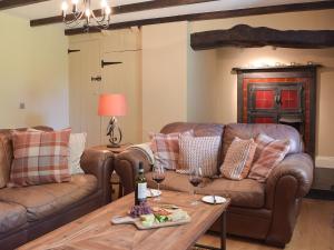 a living room with couches and a table with wine glasses at Fountain Hill in Eglwyswrw