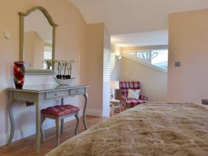 a bedroom with a bed and a vanity with a mirror at Fountain Hill in Eglwyswrw