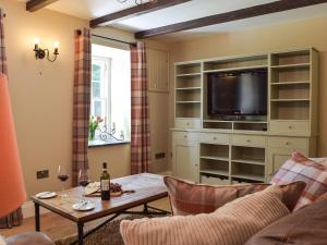 a living room with a tv and a table at Fountain Hill in Eglwyswrw +33 photos