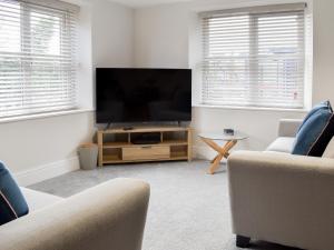 a living room with a large flat screen tv at Station Cottage in Silverdale