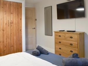 a bedroom with a bed and a dresser with a television at Station Cottage in Silverdale +11 photos