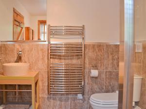 a bathroom with a toilet and a sink at Horsepark Cottage in Girthon