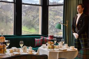 a woman standing in front of a table in a restaurant at 100 Princes Street in Edinburgh
