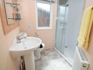 a bathroom with a toilet and a sink and a shower at Stanley's Sanctuary in Boot +3 photos