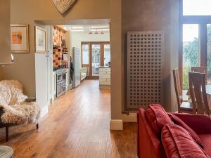 a living room with a couch and a kitchen at Olveston in Llandudno