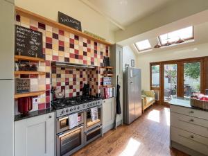 a kitchen with a stove and a refrigerator at Olveston in Llandudno