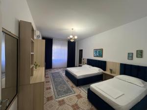 a hotel room with two beds and a bathroom at Vila BriArt in Durrës