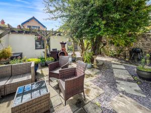 a patio with wicker chairs and a table at Olveston in Llandudno
