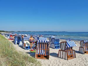 a row of beach chairs sitting on the beach at Apartment Juliusruh-6 by Interhome in Juliusruh