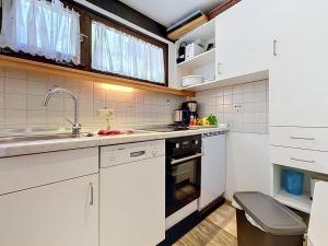 a kitchen with white cabinets and a sink at Apartment Fliederweg by Interhome in Siegsdorf