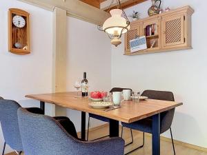 a dining room table with chairs and a clock at Apartment Fliederweg by Interhome in Siegsdorf