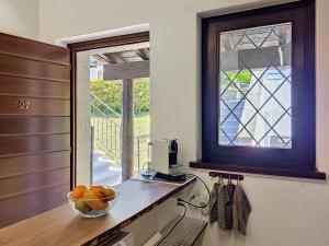 a bowl of fruit on a counter next to a window at Apartment Residenza Miralago Apt- C27 by Interhome in Piazzogna