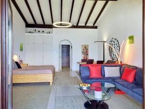 a living room with a blue couch and a bed at Apartment Residenza Miralago Apt- C27 by Interhome in Piazzogna +20 photos