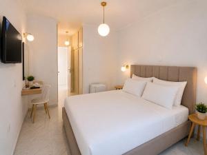 a bedroom with a large white bed and a desk at Olive Tree-Member of My Villas Hospitality in Lefkada