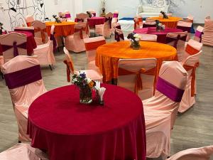 a room filled with tables and chairs with purple and orange at Cloud Bay Hotels - Sector 69 in Gurgaon