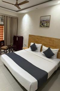 a bedroom with a large white bed with blue pillows at Cloud Bay Hotels - Sector 69 in Gurgaon