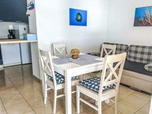a white dining room table with chairs and a kitchen at Apartment Renata by Interhome in Barić Draga