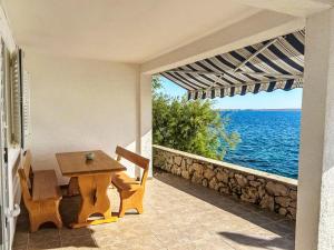 a table and chairs and a view of the ocean at Apartment Renata by Interhome in Barić Draga +35 photos