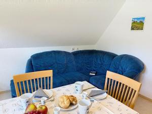 a living room with a table with a blue couch at Apartment Fischer by Interhome in Eisenbach