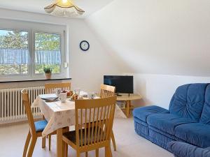 a living room with a table and a blue couch at Apartment Fischer by Interhome in Eisenbach