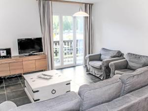 a living room with a couch and chairs and a tv at Apartment Andromède 3-pièces A34 by Interhome in Moleson
