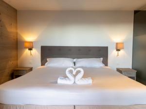 two swans carved into towels on a bed at Apartment Le Refuge 1 by Interhome in Nendaz