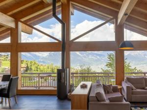 a living room with a large window with mountains at Chalet D'Arby by Interhome in Nendaz