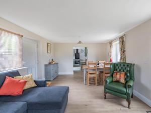 a living room with a couch and a dining room at Orchard Barns in North Nibley