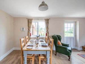 a dining room with a table and chairs at Orchard Barns in North Nibley