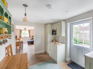 a kitchen with a table and a dining room at Orchard Barns in North Nibley