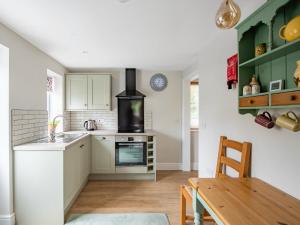 a kitchen with a sink and a stove top oven at Orchard Barns in North Nibley