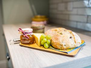 a loaf of bread and grapes on a cutting board at Orchard Barns in North Nibley +13 photos