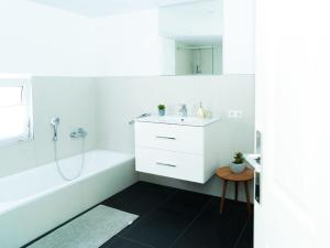 a white bathroom with a sink and a bath tub at Travetraum in Lübeck +42 photos