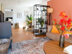 a living room with a couch and a table with flowers at Travetraum in Lübeck