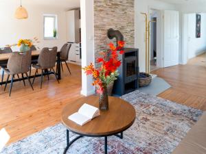 a living room with a fireplace and a table with flowers at Travetraum in Lübeck
