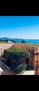 a bench covered in green bushes next to a building at Bungalow sul mare in Costa Rei